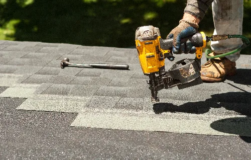 Roofer patching and repairing damaged shingles